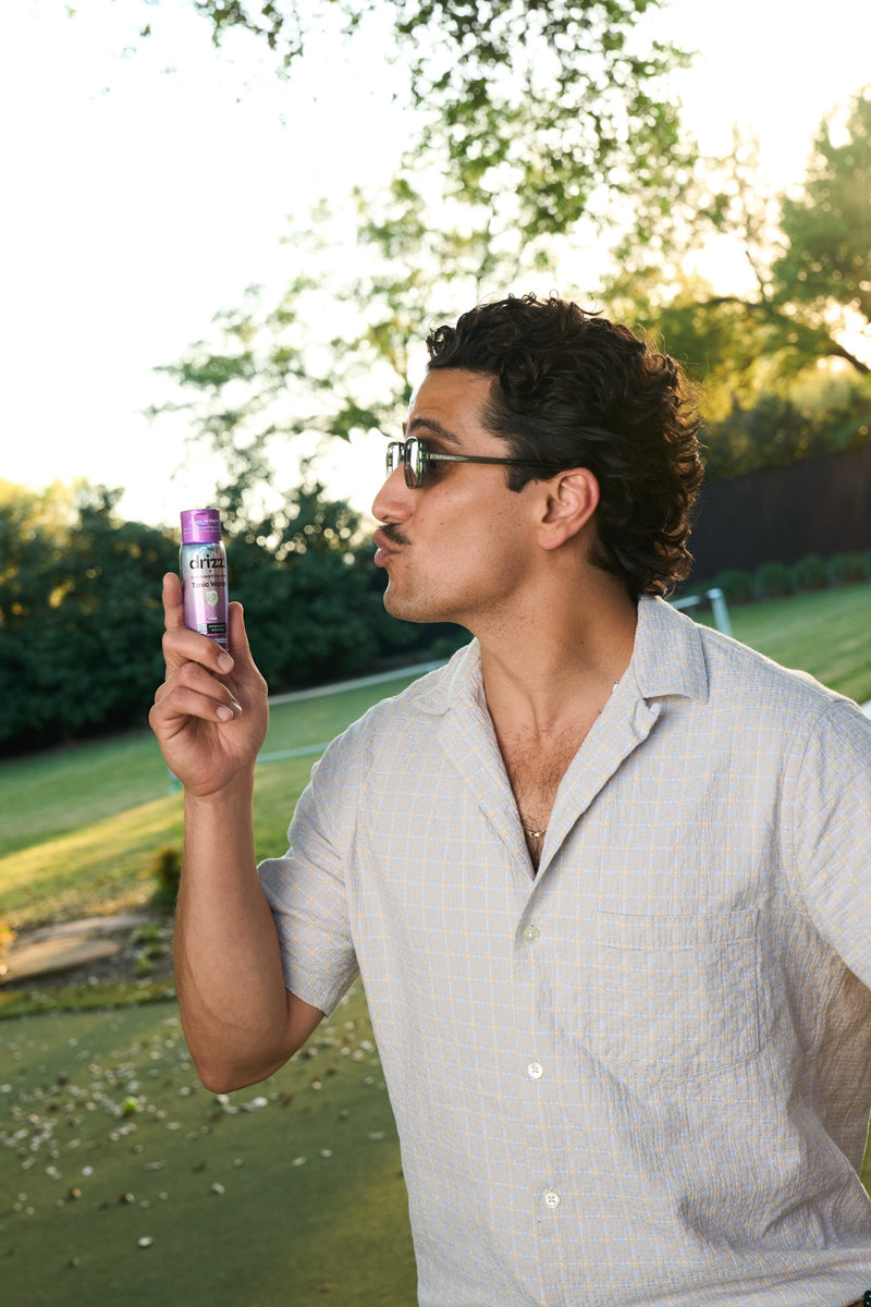 Guest holding Drizz Tonic Mixer Drops at a community event