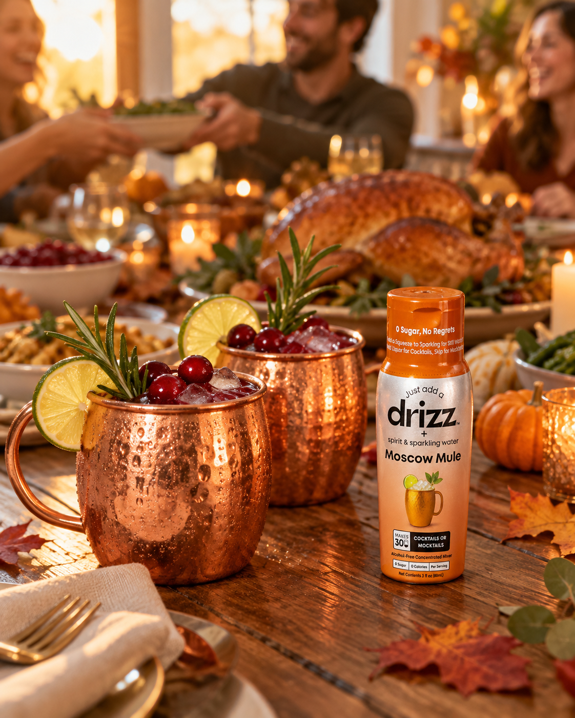 Cranberry mule mocktails in copper mugs on a Thanksgiving dinner table next to a bottle of Drizz Moscow Mule Mixer Drops