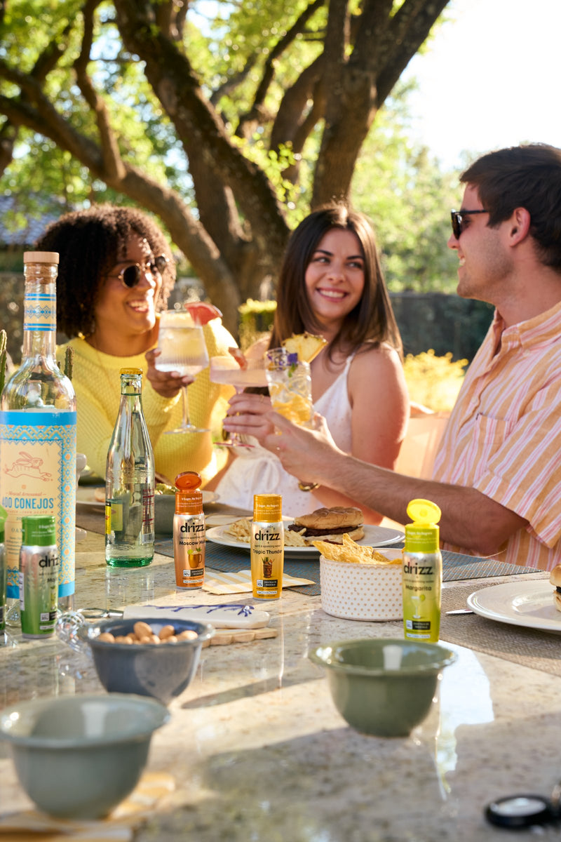 Friends raising drinks around a backyard table
