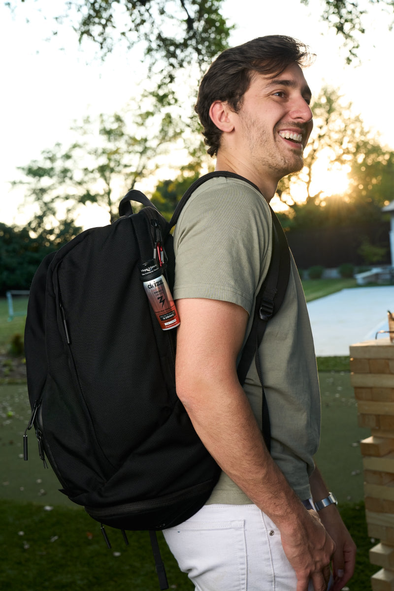 Hiker with Drizz clipped to his backpack at sunset