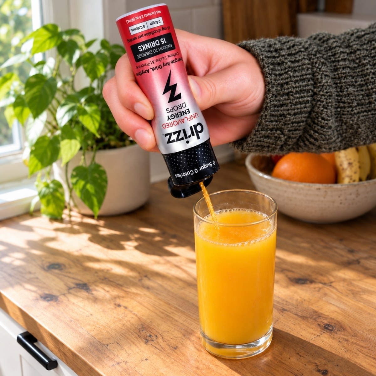 Squeezing Drizz Unflavored Energy Drops into a glass of orange juice
