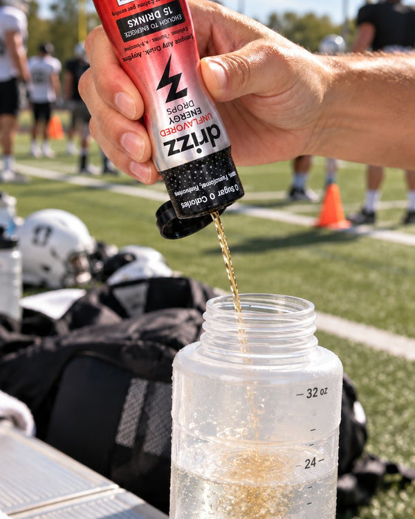 Squeezing Drizz Energy Drops into a water bottle on a football sideline